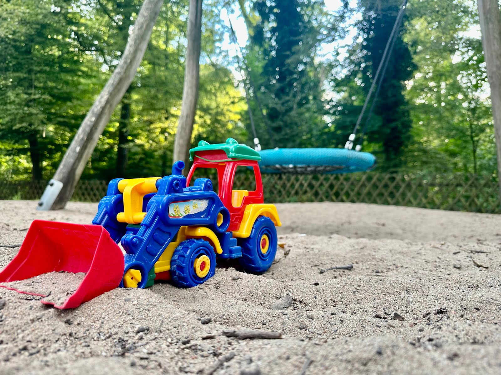 Symbolfoto Spielzeug-Bagger auf einem Spielplatz.