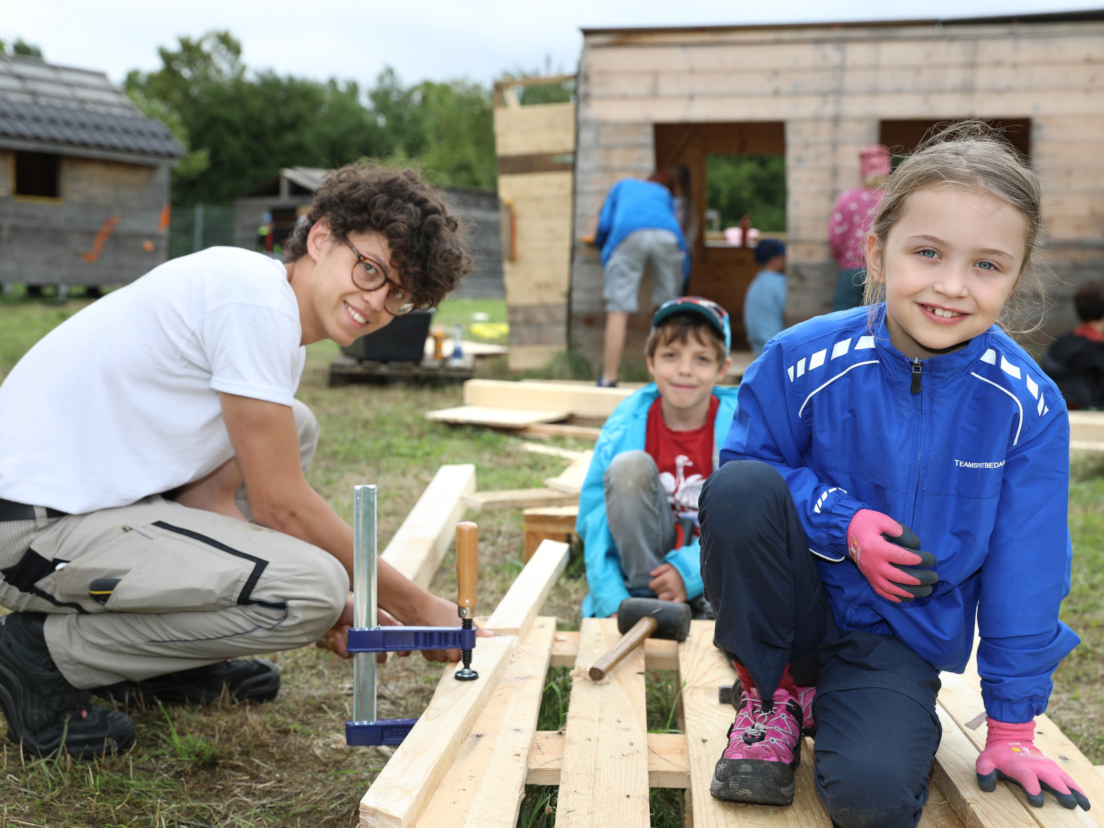 Kinder und Betreuende arbeiten gemeinsam auf der Kinderbaustelle.